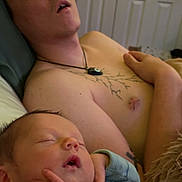 Atlas is registered to the contest to win money with this photo: sleeping, baby, adult, tattoo, necklace, bedroom, peaceful, rest, child, face, hand, shirtless, furniture, decor, indoors, person, cozy, relaxation, portrait, home