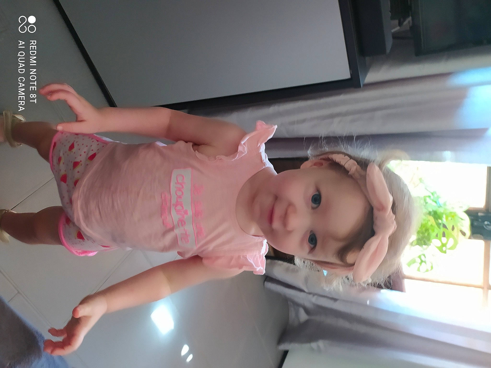 Maëva participe au concours pour gagner de l'argent avec cette photo : automotive_exterior, baby, baby_products, baby_toddler_clothing, chest, child, dress, elbow, fun, headwear, human_body, human_leg, leg, mouth, person, plant, room, shoulder, smile, thigh