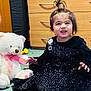 Rijak Kaur is registered to the contest to win money with this photo: toddler, child, smiling, black_dress, sequin, barefoot, hair_tied, teddy_bear, pink_bow, carpet, dresser, wooden_furniture, indoors, cute, happy, playful, person, toy, floor, home