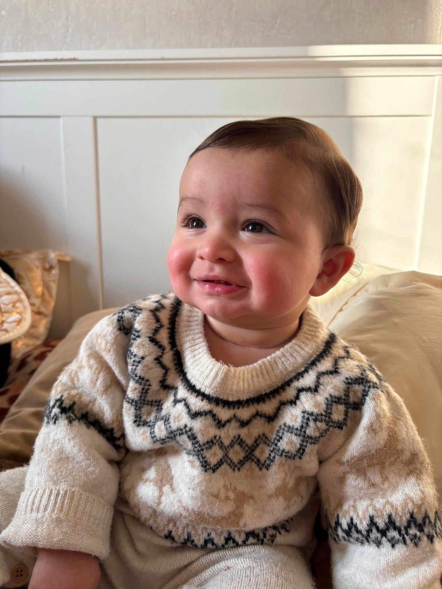 Yanis a rejoint le concours — aidez-le/la à gagner de superbes lots ! baby, child, smiling, sweater, indoor, cozy, patterned_clothing, face, cheeks, person, cute, warm_light, seated, portrait, infant, soft_texture, head, happy, young, rosy_cheeks