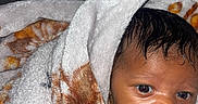 Atlantis joined the competition — help win amazing prizes! baby, blanket, wrapped, curious, infant, face, expression, soft_texture, warm, patterned_blanket, young_child, indoors, portrait, cute, skin, head, eyes, mouth, newborn, cozy