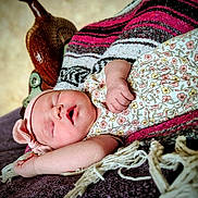 Jolene is registered to the contest to win money with this photo: baby, infant, sleeping, headband, floral_outfit, blanket, cozy, peaceful, hand, face, skin, portrait, rest, cute, newborn, indoors, soft_light, closeup, toddler, relaxation