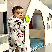 Zendaya a rejoint le concours — aidez-le/la à gagner de superbes lots ! toddler, child, mickey_mouse, onesie, playhouse, indoor, curious, floor, clothing, toy, person, standing, face, expression, hooded, baby, play, footwear, room, young