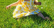 Zendaya participe au concours pour gagner de l'argent avec cette photo : toddler, child, grass, outdoor, sunhat, dress, yellow_flower, greenery, summer, nature, garden, sunlight, barefoot, curious, sitting, fence, daylight, playful, person, portrait