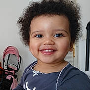 Mylvia participe au concours pour gagner de l'argent avec cette photo : child, toddler, smile, curly_hair, indoor, face, happy, clothing, person, baby, table, furniture, stroller, pink, white, eyes, mouth, skin, head, cute