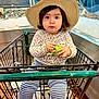 toddler, child, shopping_cart, hat, grocery_store, seafood, container, clothing, striped_pants, sneakers, indoor, person, retail, aisle, holding, face, eyes, cute, curious, shopping