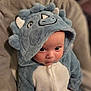 Arthur participe au concours pour gagner de l'argent avec cette photo : baby, blue, child, clothing, costume, cozy, curious, cute, dinosaur, expression, face, hoodie, indoor, infant, person, plush, portrait, seated, soft, young