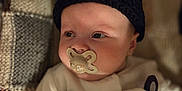 Arthur participe au concours pour gagner de l'argent avec cette photo : baby, infant, pacifier, hat, knit_hat, bear_ears, panda_outfit, cute, sleepwear, blanket, patchwork, soft_lighting, portrait, child, newborn, cozy, indoor, closeup, face, expression