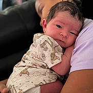 Nasir joined the competition — help win amazing prizes! adult, animal_print, baby, blurred_background, closeup, couch, cozy, diaper, face, family, holding, indoor, infant, love, newborn, onesie, portrait, snuggling, soft_lighting, tenderness