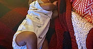 Kyran is registered to the contest to win money with this photo: baby, infant, sleeping, blanket, onesie, dinosaur_print, feet, toes, cozy, red, black, fabric, indoors, rest, child, cute, soft, peaceful, nap, person