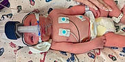 Theo is registered to the contest to win money with this photo: newborn, baby, hospital, medical_equipment, breathing_mask, monitoring_wires, hand, diaper, blanket, infant, person, healthcare, care, resting, tiny, cute, skin, lying_down, bed, patient