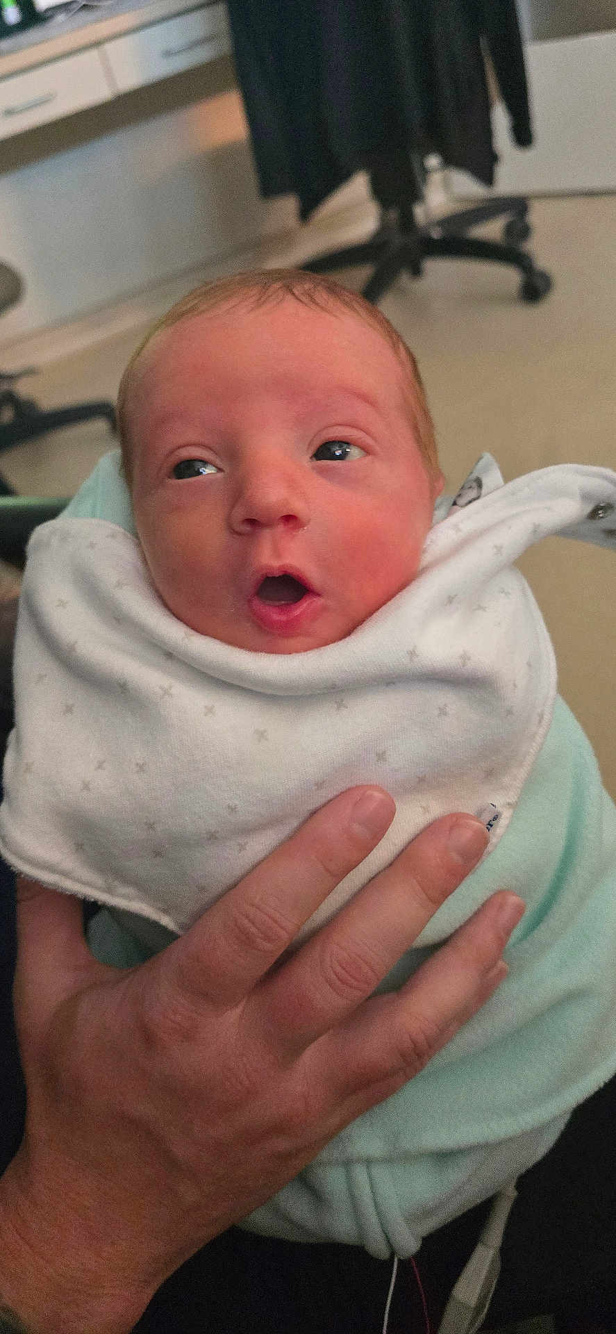 Theo is registered to the contest to win money with this photo: newborn, baby, infant, hand, blanket, clothing, face, person, indoor, expression, surprised, holding, skin, human, portrait, cute, small, soft, wrapped, resting