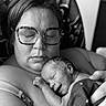 newborn, baby, infant, adult, parent, sleeping, cuddling, portrait, black_and_white, monochrome, glasses, eyeglasses, blanket, star_pattern, close_up, indoors, family, tender, resting, photography