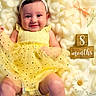 baby, child, yellow_dress, headband, white_bow, fluffy_blanket, wooden_blocks, flowers, ribbons, smiling, happy, infant, cute, portrait, laying_down, soft_texture, decorative, indoors, skin, legs