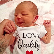 Sabina is registered to the contest to win money with this photo: baby, blanket, cute, heart, holding_hand, human, indoor, infant, love_message, newborn, onesie, pink, portrait, sleeping, small_hand, soft_texture, tattoo, text_on_clothing, toddler, white