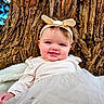 baby, child, smiling, headband, dress, tree_trunk, outdoor, nature, cute, portrait, infant, happy, face, skin, person, tulle, fabric, texture, young, closeup