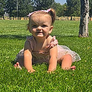 Eleanor joined the competition — help win amazing prizes! baby, bow, child, crawling, dress, grass, greenery, happy, nature, outdoor, park, person, playful, sky, smile, summer, sunlight, toddler, trees, young_child