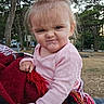 toddler, child, outdoor, blanket, pink_clothing, expression, face, hair, trees, nature, park, person, cute, cold_weather, holding, red, white, patterned_blanket, funny_face, portrait