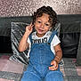 Karnelo joined the competition — help win amazing prizes! arm_jewelry, casual_clothing, child, couch, cozy, curly_hair, cushion, denim_overalls, happy, indoor, peace_sign, person, playful, portrait, relaxed, sitting, smiling, textured_wall, white_tshirt, young_child
