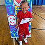 Karnelo is registered to the contest to win money with this photo: achievement, athlete, braided_hair, celebration, certificate, child, colorful_background, gymnasium, happy, indoor, person, portrait, proud, red_clothing, red_socks, smiling, sports_event, sportswear, white_shoes, wooden_floor