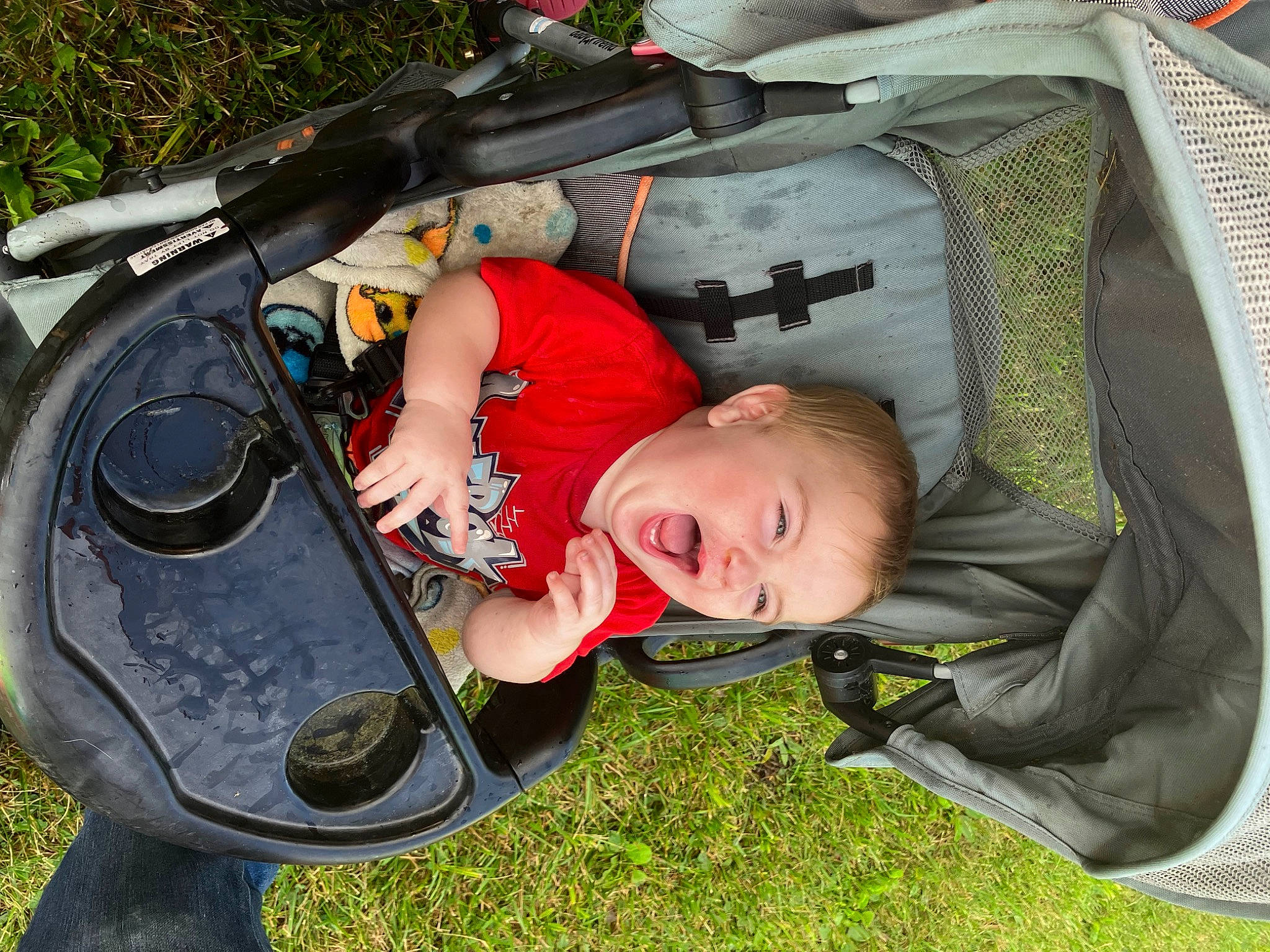 Braxten is registered to the contest to win money with this photo: auto_part, automotive_exterior, baby, baby_carriage, baby_products, bag, bumper, child, comfort, fun, grass, lawn, leisure, motor_vehicle, person, plant, product, recreation, smile, toddler