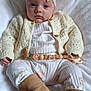 Erin joined the competition — help win amazing prizes! baby, infant, headband, bow, knitwear, cardigan, boots, blanket, pacifier, beige, white, soft_toys, clothing, cute, portrait, child, indoors, person, comfortable, resting
