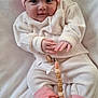 Erin is registered to the contest to win money with this photo: baby, infant, hat, pink, white_clothing, pacifier, pacifier_clip, blanket, lying_down, cute, hand, sock, soft_texture, indoors, child, smiling, face, clothing, cozy, portrait
