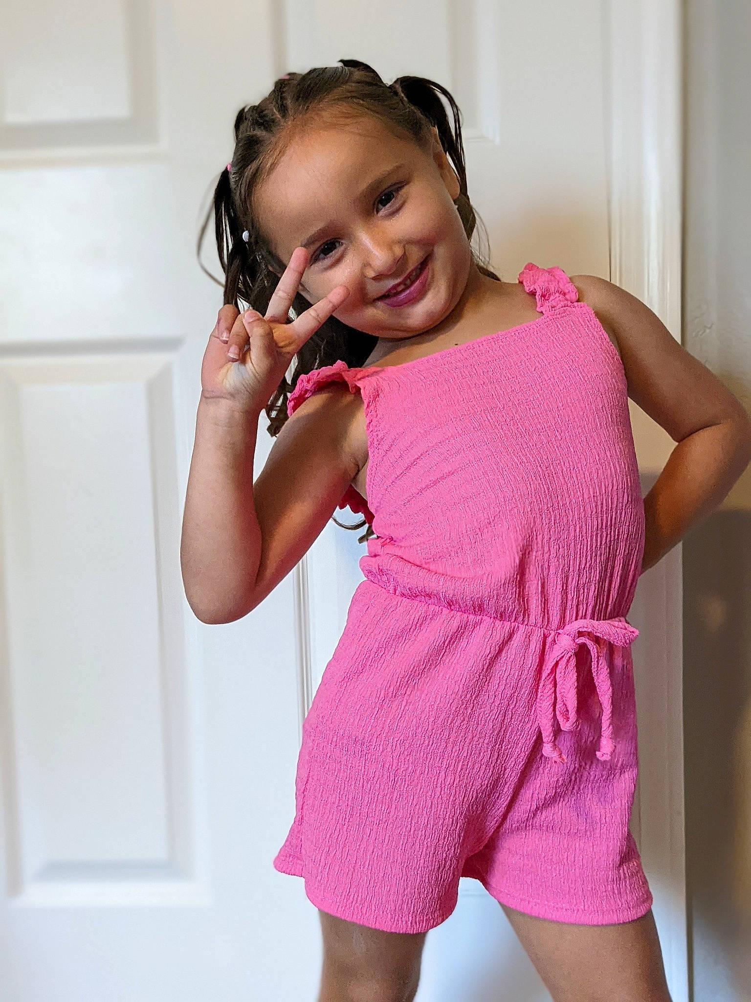 Micaela is registered to the contest to win money with this photo: baby_toddler_clothing, day_dress, dress, elbow, eye, face, flash_photography, gesture, hair, hand, happy, human_body, joy, neck, one_piece_garment, person, pink, sleeve, smile, thigh