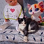 cat, doll, pillow, bed, blanket, fabric, pattern, black_and_white, toy, indoor, cute, animal, plush, resting, soft, decor, vintage, child, colorful, nap