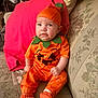 Serenity joined the competition — help win amazing prizes! baby, pumpkin_costume, orange_clothing, hat, socks, sitting, couch, floral_pattern, indoor, child, cute, portrait, holiday, halloween, expression, homedecor, furniture, infant, face, person