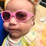 Serenity joined the competition — help win amazing prizes! baby, child, sunglasses, pink_sunglasses, face, head, clothing, onesie, tie_dye, indoor, table, cup, dunkin, button, person, portrait, close_up, infant, casual, colorful
