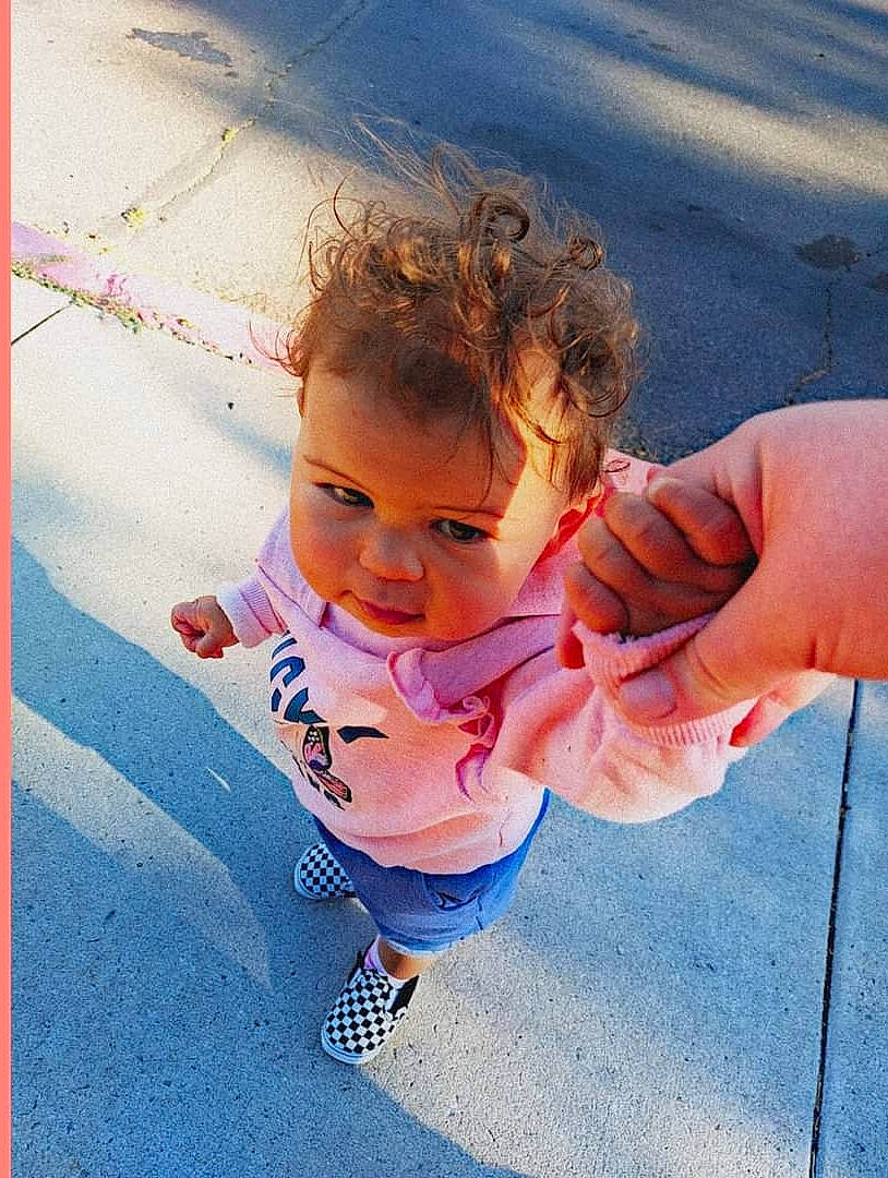 Dorothy is registered to the contest to win money with this photo: asphalt, blond, body_of_water, child, electric_blue, eye, eyewear, fun, gesture, grass, happy, head, leisure, orange, people_in_nature, person, recreation, sand, sunglasses, thumb