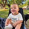 baby, child, smiling, sitting, portrait, outdoor, backyard, tree, grass, dog, pet, stroller, sneaker, white_shirt, clothing, sunlight, chair, nature, happy, face