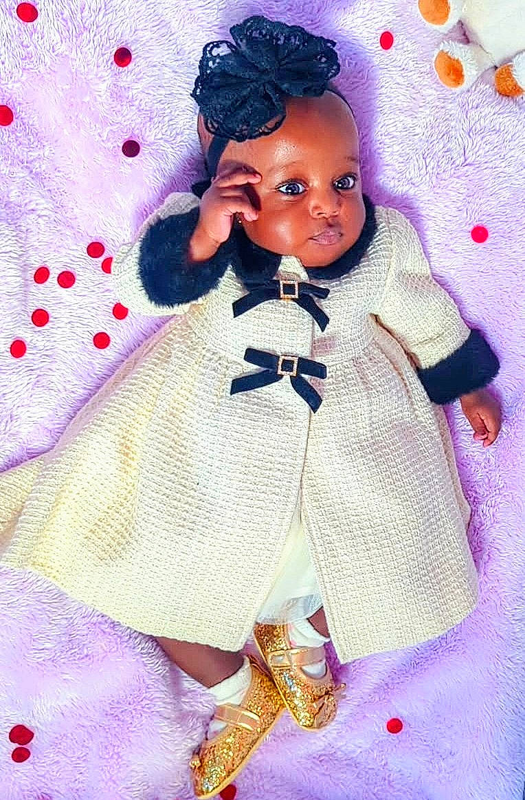 Taiwo joined the competition — help win amazing prizes! adorable, baby, black_bow, blanket, child, coat, confetti, cute, fashion, golden_shoes, happy, headband, indoors, infant, lace, lying_down, portrait, purple_blanket, soft_texture, sparkly