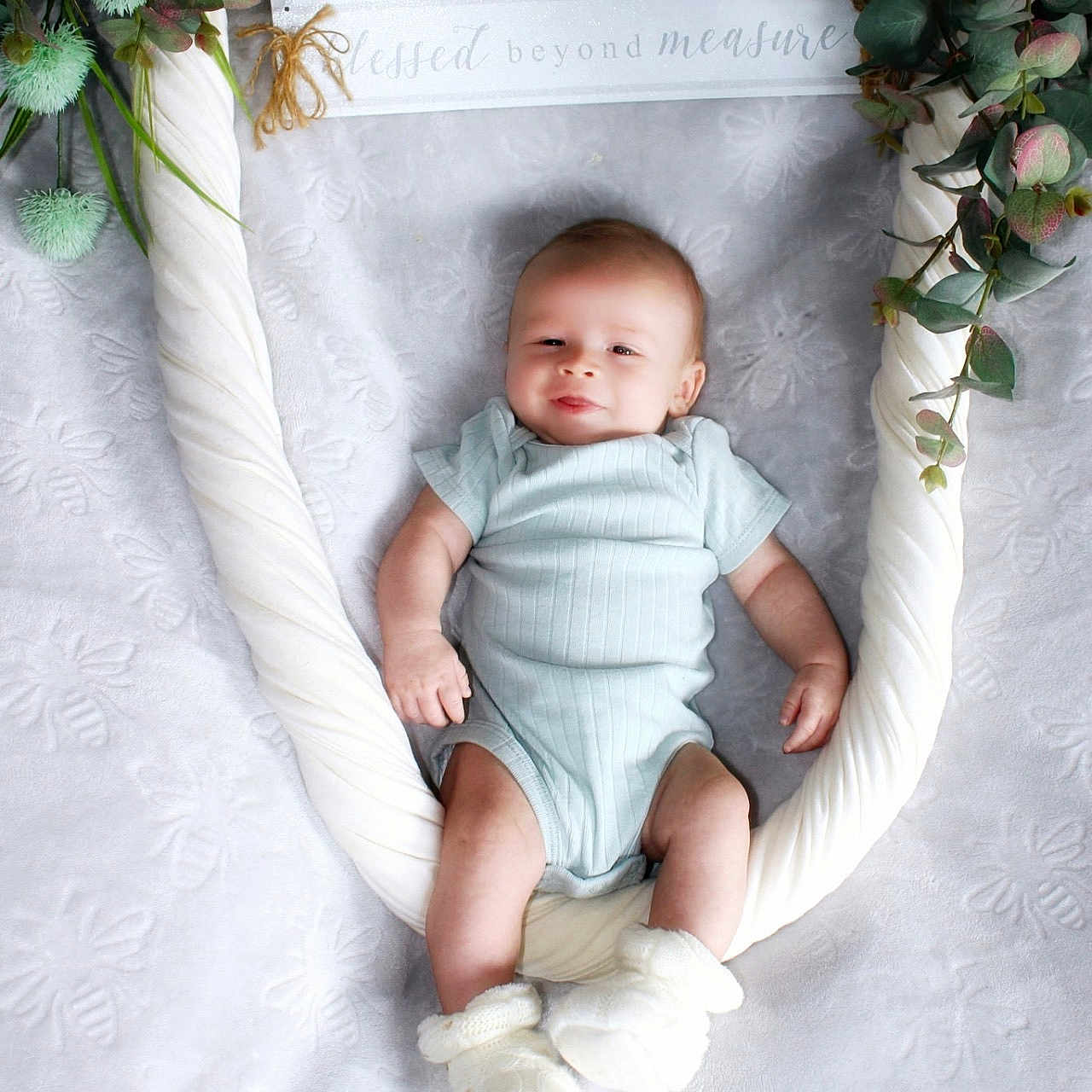 Liam joined the competition — help win amazing prizes! baby, blanket, booties, cute, decor, fabric, face, foliage, greenery, happy, indoor, infant, lying_down, onesie, portrait, sign, smiling, soft_texture, swing, text