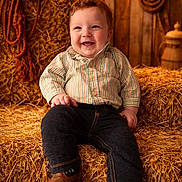 Colbin Shean joined the competition — help win amazing prizes! toddler, child, smiling, hay_bales, cowboy_hat, rope, barn, rustic, jeans, striped_shirt, boots, wooden_wall, string_lights, indoors, portrait, happy, seated, warm_lighting, farm, clothing