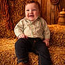 toddler, child, smiling, hay_bales, cowboy_hat, rope, barn, rustic, jeans, striped_shirt, boots, wooden_wall, string_lights, indoors, portrait, happy, seated, warm_lighting, farm, clothing