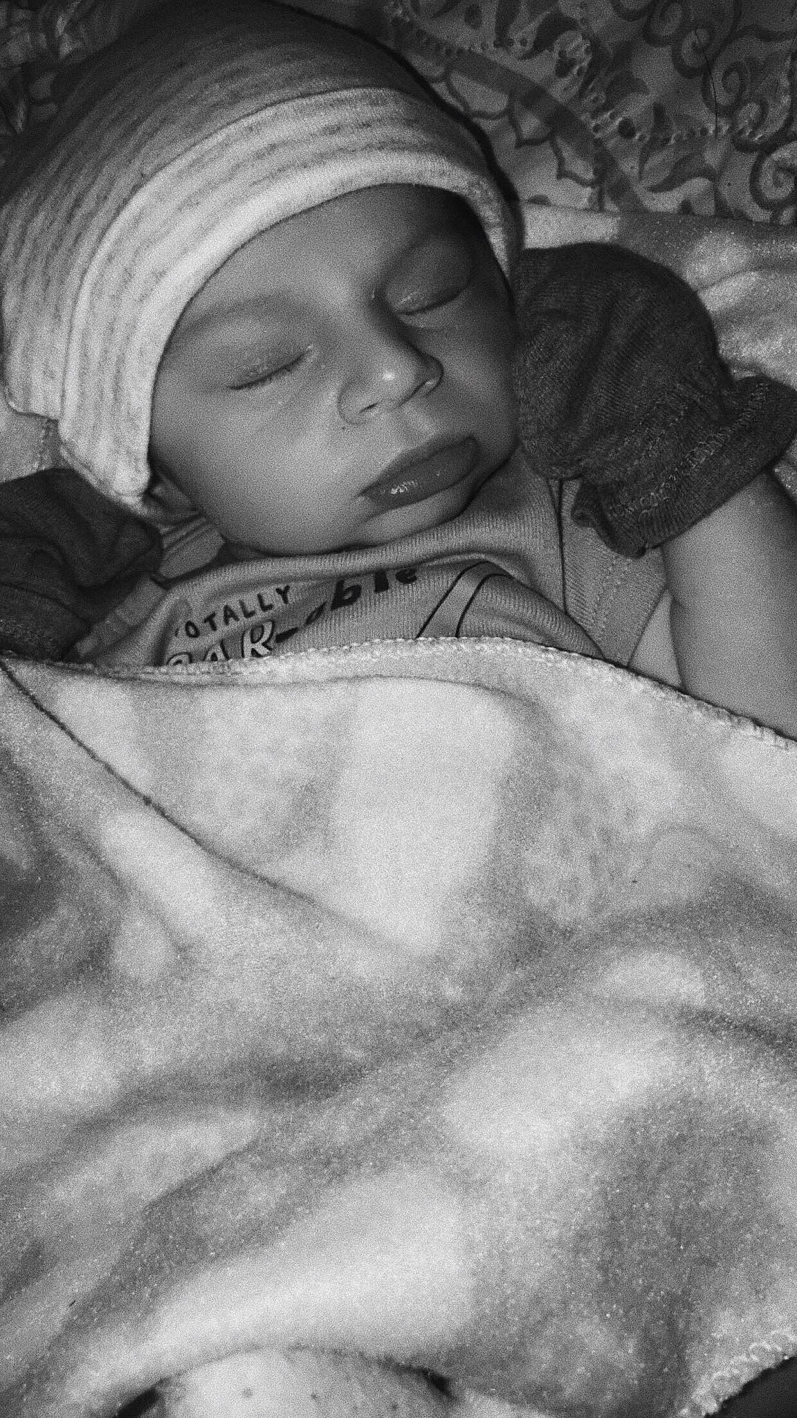 Bennett is registered to the contest to win money with this photo: art, baby, black, cap, cheek, child, comfort, eyebrow, facial_expression, grey, happy, headwear, human, linens, monochrome, monochrome_photography, people, person, skin, style