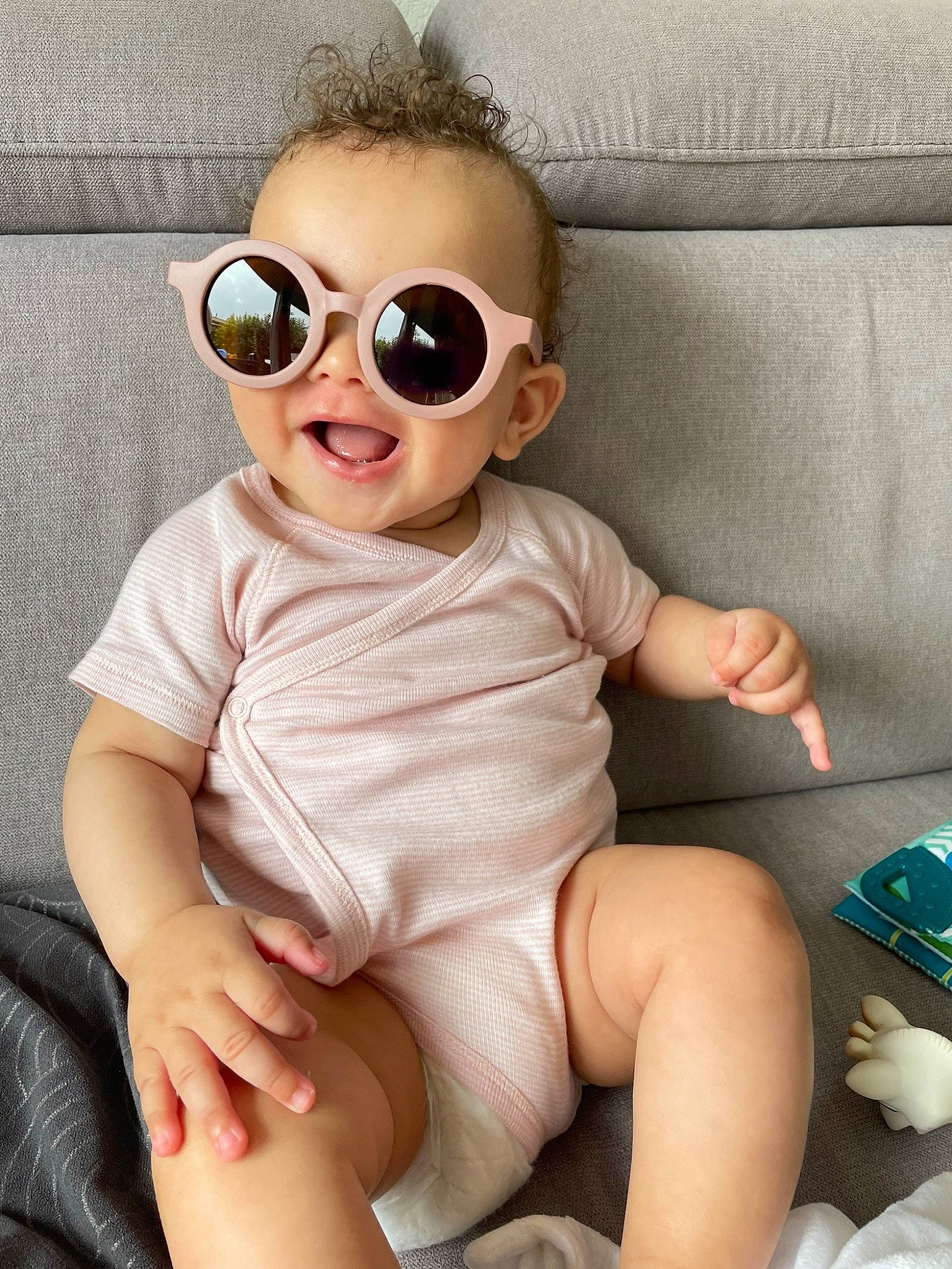 Kiara a rejoint le concours — aidez-le/la à gagner de superbes lots ! baby, baby_toddler_clothing, cheek, child, comfort, couch, eyewear, goggles, happy, human_leg, knee, pattern, person, shorts, sitting, skin, sleeve, smile, sock, thigh