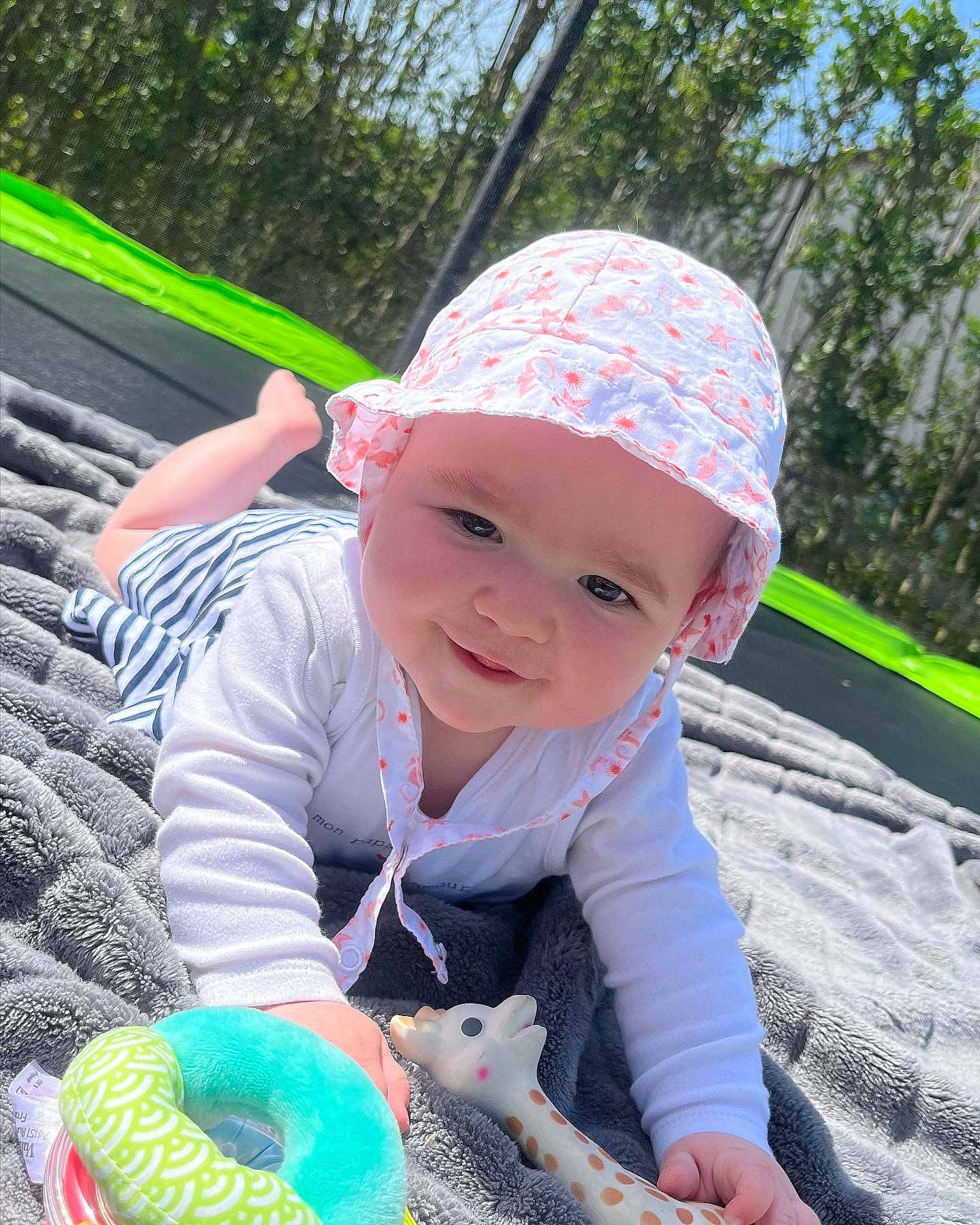 Jade a rejoint le concours — aidez-le/la à gagner de superbes lots ! baby, baby_products, baby_toddler_clothing, baseball_cap, cap, child, electric_blue, fashion_accessory, fun, grass, happy, headwear, leisure, people_in_nature, person, play, recreation, sitting, sky, smile