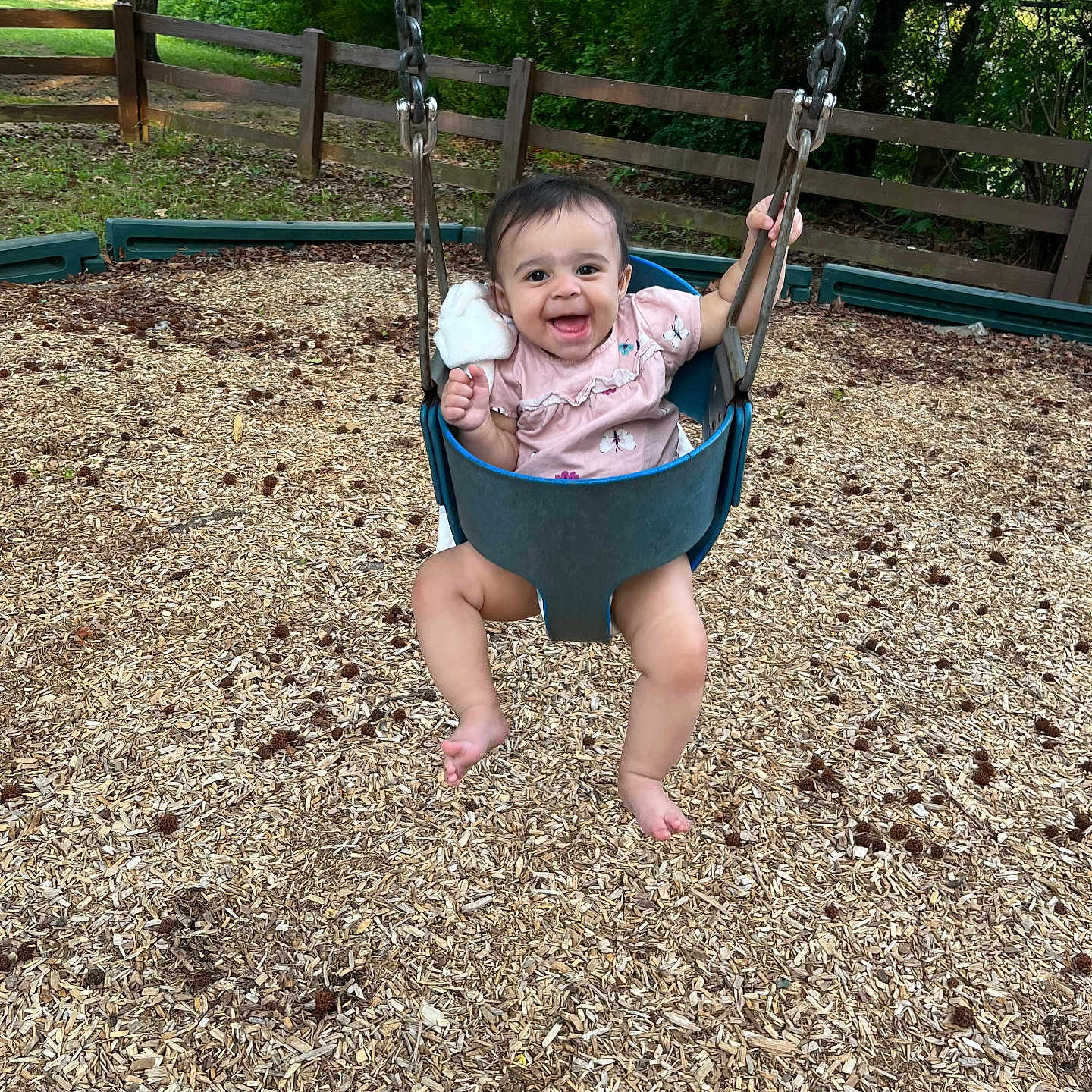 Kamayah joined the competition — help win amazing prizes! baby, swing, playground, child, smiling, happy, outdoor, woodchips, greenery, tree, fence, clothing, person, seat, fun, nature, toy, baby_clothes, summer, park