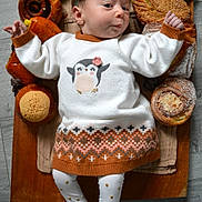 Hana participe au concours pour gagner de l'argent avec cette photo : baby, infant, child, pastries, bread, croissant, cinnamon_roll, wooden_board, sweater, headband, penguin_design, leggings, floor, food, breakfast, cute, cozy, expression, lying_down, indoors
