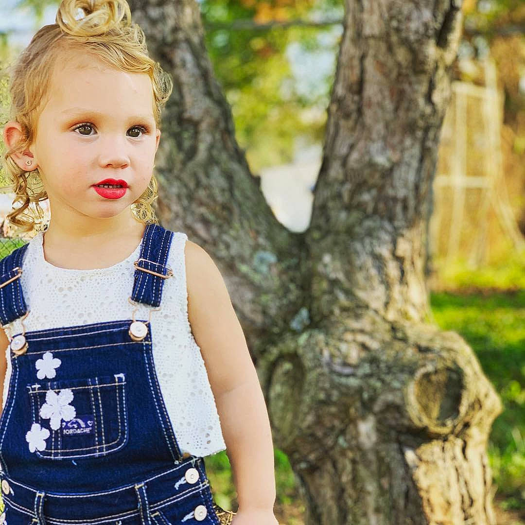 Melina is registered to the contest to win money with this photo: blond, branch, child, child_model, denim, design, fawn, jeans, outerwear, overall, pattern, person, plaid, plant, sunlight, toddler, tree, trunk, waist, woody_plant