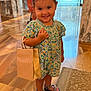 Lia is registered to the contest to win money with this photo: background_blur, child, cute, fashion, floral_dress, girl, happy, indoor, person, portrait, retail, rug, sandals, shopping_bag, shopping_mall, smiling, standing, store, toddler, wooden_floor
