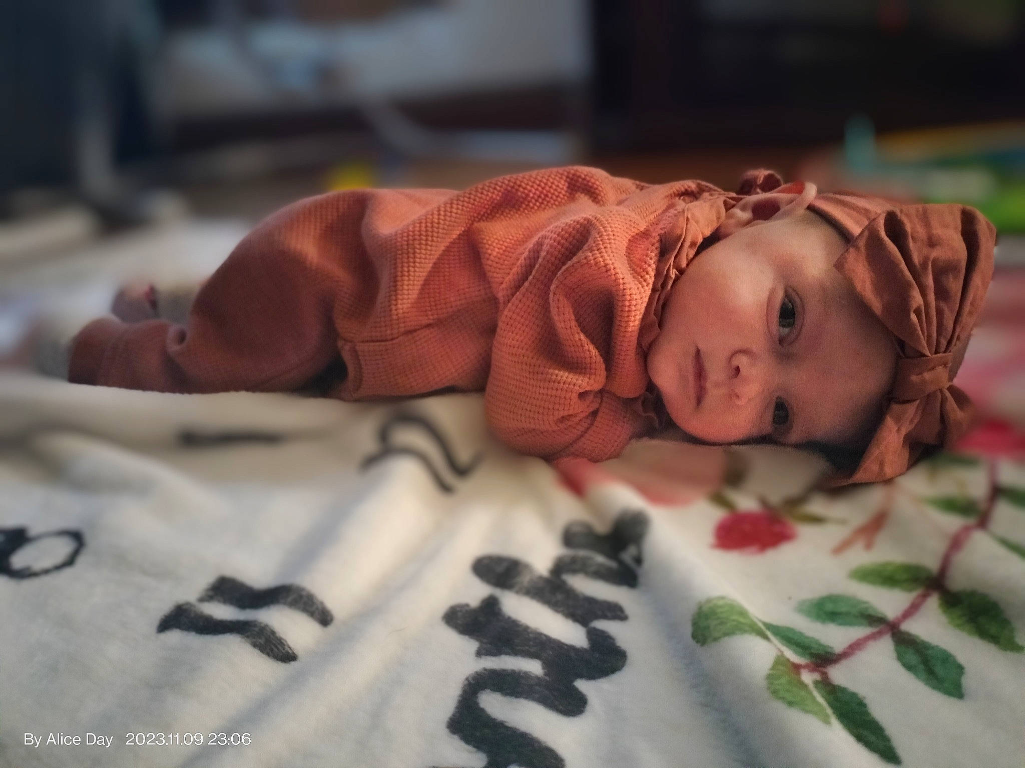 Maci is registered to the contest to win money with this photo: baby, bed_sheet, bedding, bedtime, child, comfort, eye, face, flesh, flooring, font, grass, head, headwear, linens, pattern, person, room, skin, textile