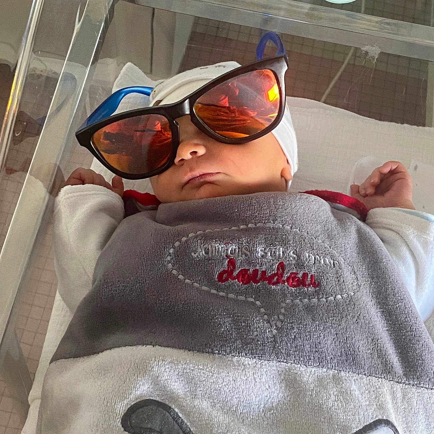 Leâo participe au concours pour gagner de l'argent avec cette photo : accessories, architecture, baby, blanket, clothing, crib, face, furniture, glasses, hat, head, infantbed, person, photography, portrait, selfie, sleeping, sunglasses, t_shirt, towel