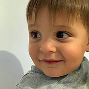 Rafaël a rejoint le concours — aidez-le/la à gagner de superbes lots ! child, toddler, face, portrait, smile, curious, eyes, hair, skin, clothing, gray_shirt, indoors, close_up, person, cute, baby, young, expression, head, background