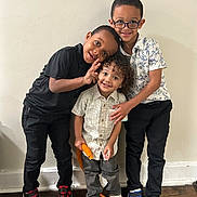 Carter is registered to the contest to win money with this photo: children, kids, siblings, group_portrait, smiling, peace_sign, eyeglasses, indoor, portrait, standing, friendship, family, casual_clothing, colorful_sneakers, hardwood_floor, wall, playful, happy, young_people, photography