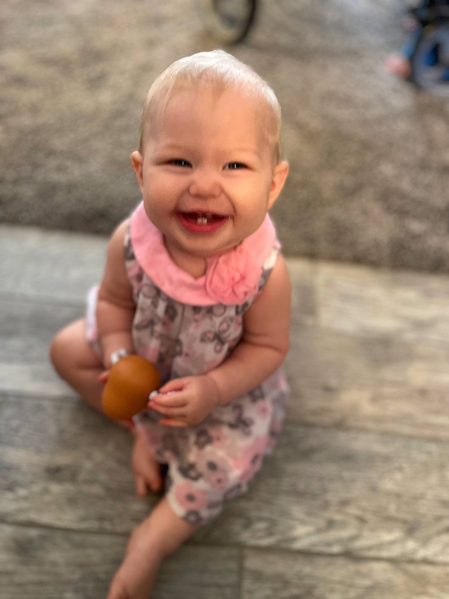 Sophie is registered to the contest to win money with this photo: asphalt, baby_toddler_clothing, facial_expression, fun, gesture, grass, hairstyle, happy, human, joy, leisure, mammal, people_in_nature, person, pink, skin, smile, standing, tire, toddler