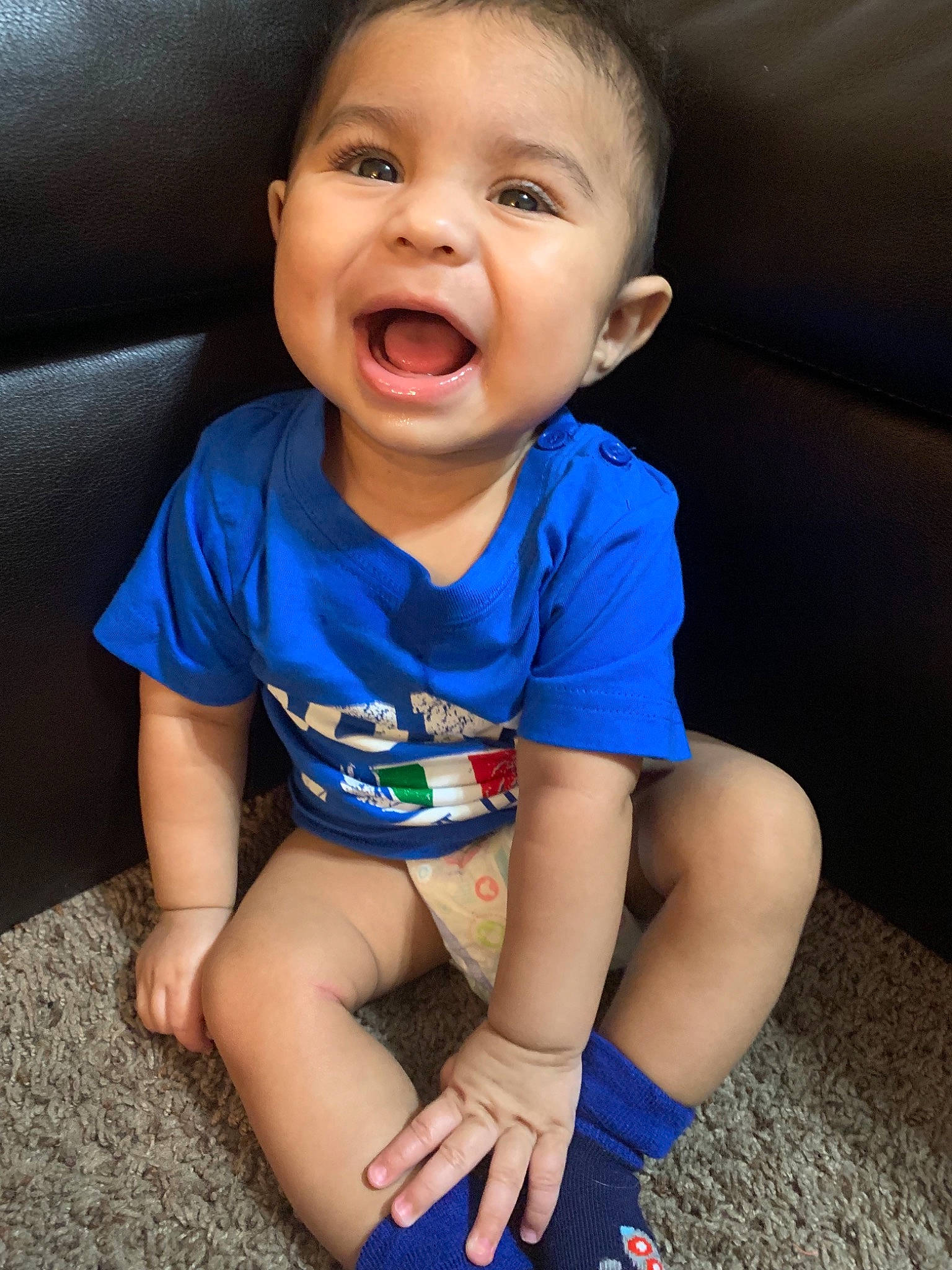 Raymond is registered to the contest to win money with this photo: arm, baby, beauty, blue, cheek, child, chin, eye, face, facial_expression, fun, head, leg, lip, mouth, nose, person, sitting, skin, smile